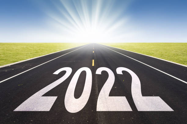 istock 2022 road perspective with rising sun, new year card 1346148410