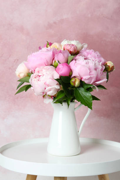 istock Bouquet of beautiful peonies in vase on white table 1346149806