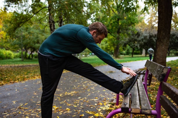 istock Young man stretching leg in the park 1346151316