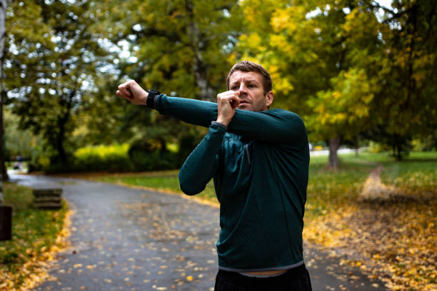 istock Young man stretching before running in city park 1346151318