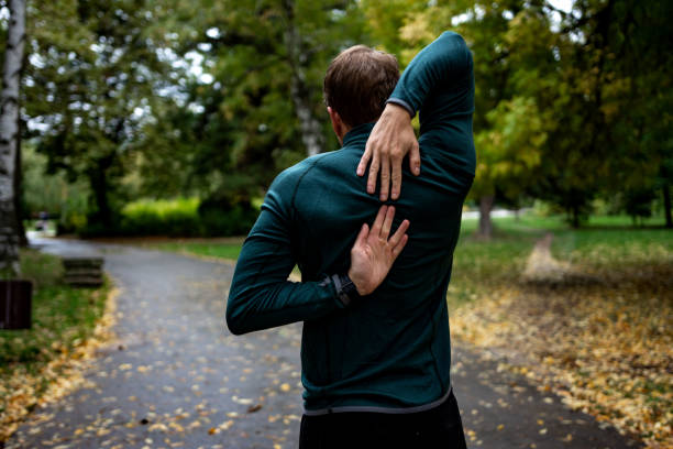 istock Young man stretching before running in city park 1346151319
