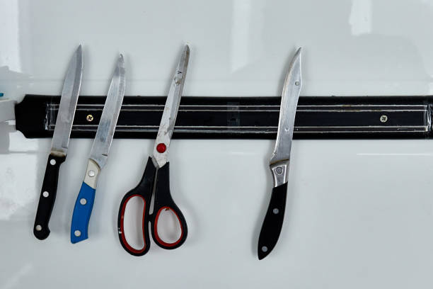 knives and scissors hanging on the wall on a magnetic holder