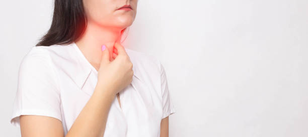 the girl holds on to the sore red throat on a white background. concept of sore throat, laryngitis and sore throat in coronavirus. copy space for text - tonsill bildbanksfoton och bilder