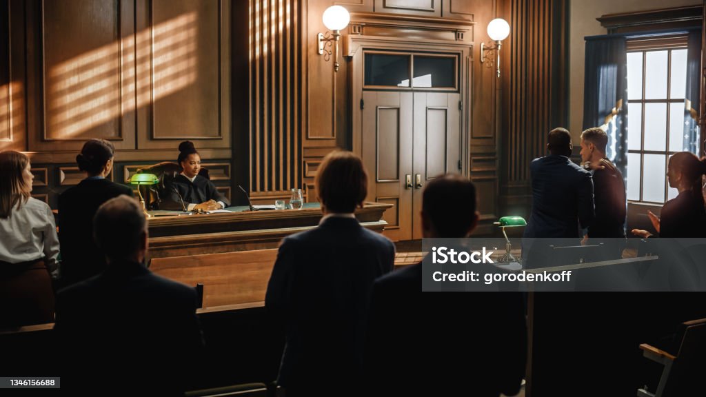Court of Law and Justice Trial: Judge Ruling Out a Positive Decision in a Civil Family Case, Striking Gavel to End Hearing. Defendant Party is Happy, Barrister Cheering Client. Courthouse Stock Photo
