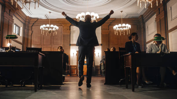 суд и судебный процесс: мужчина-общественный защитник выигрывает дело, медленно уходит с поднятыми руками. успешный афроамериканский адво� - суд стоковые фото и изображения