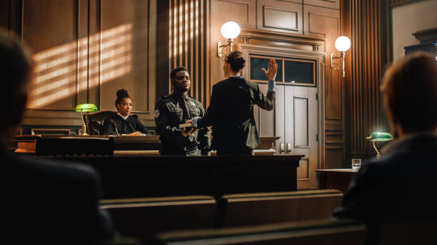 a testemunha do caso do tribunal de justiça jura solenemente que as provas que ela dará serão a verdade e nada além da verdade antes de testemunhar aos advogados e juiz no tribunal. - lawyer justice legal system law - fotografias e filmes do acervo