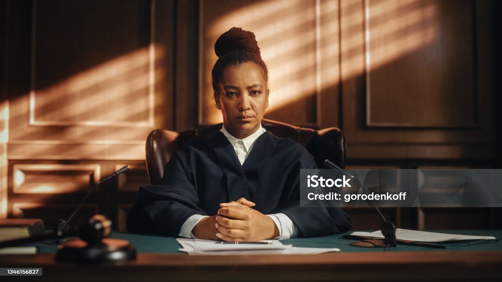 Cinematic Court of Law Trial: Portrait of Impartial Thoughtful Female Judge Looking at Camera. Wise, Incorruptible, Fair Justice Doing Her Job Professionally, Sentencing Criminals, Protecting Innocent Judge - Law Stock Photo