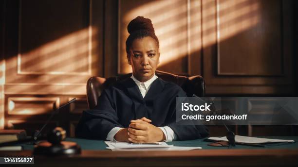 Cinematic Court Of Law Trial Portrait Of Impartial Thoughtful Female Judge Looking At Camera Wise Incorruptible Fair Justice Doing Her Job Professionally Sentencing Criminals Protecting Innocent Stock Photo - Download Image Now