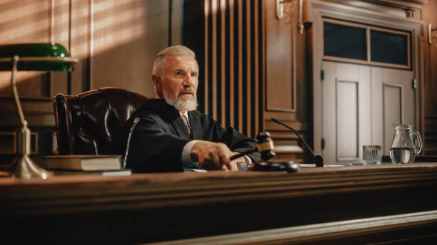 istock Court of Law Trial: Portrait of Impartial Judge Reading Decision, striking Gavel. Justice Pronouncing Sentence. Judgment after Deliberation. Guilty, Not Guilty Verdict. Cinematic Concept Rule of Law 1346156841
