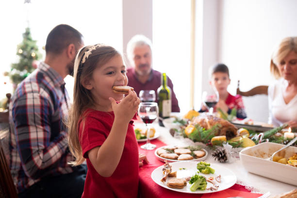 маленькая девочка на рождественском праздничном ужине с семьей - drinking little girls women wine стоковые фото и изображения