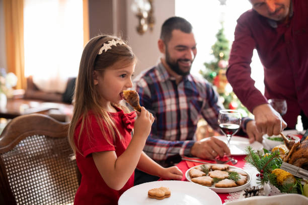 маленькая девочка на рождественском праздничном ужине с семьей - drinking little girls women wine стоковые фото и изображения
