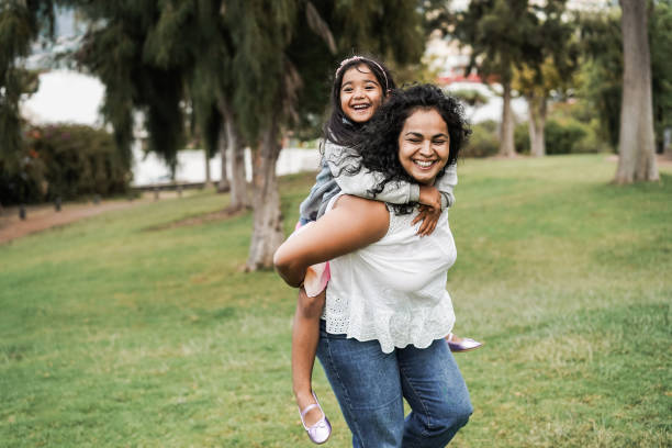 Happy indian mother having fun with her daughter outdoor - Focus on mother face Happy indian mother having fun with her daughter outdoor - Focus on mother face indian woman laughing stock pictures, royalty-free photos & images