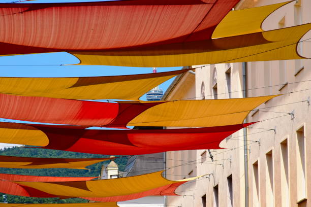 bunte segeltuch-sonnenschutz-markisen über der einkaufsstraße. reisen und tourismus - shade sail awning textile stock-fotos und bilder