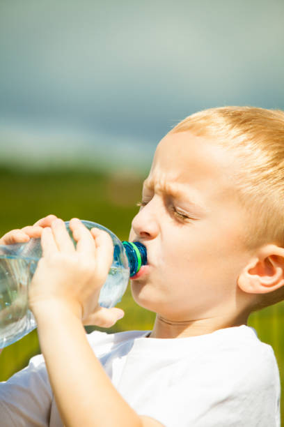 istock Little boy drink water from bottle, outdoor 1346160620