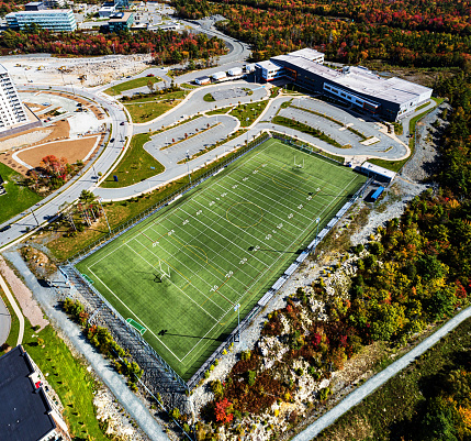 Aerial drone view of a public high school with football field.