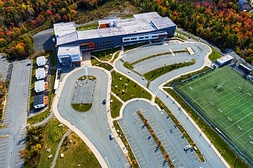 Aerial drone view of a high school with football field.