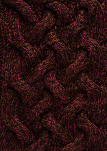 istock Texture of smooth knitted dark sweater with pattern. Top view, close-up. Handmade knitting wool or cotton fabric texture. Background of knitting patterns with a vertical large Braid Cable. 1346163486