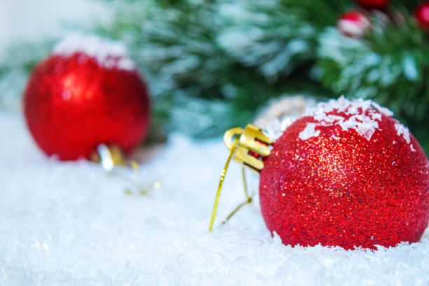 Red and gold Christmas baubles on snow.