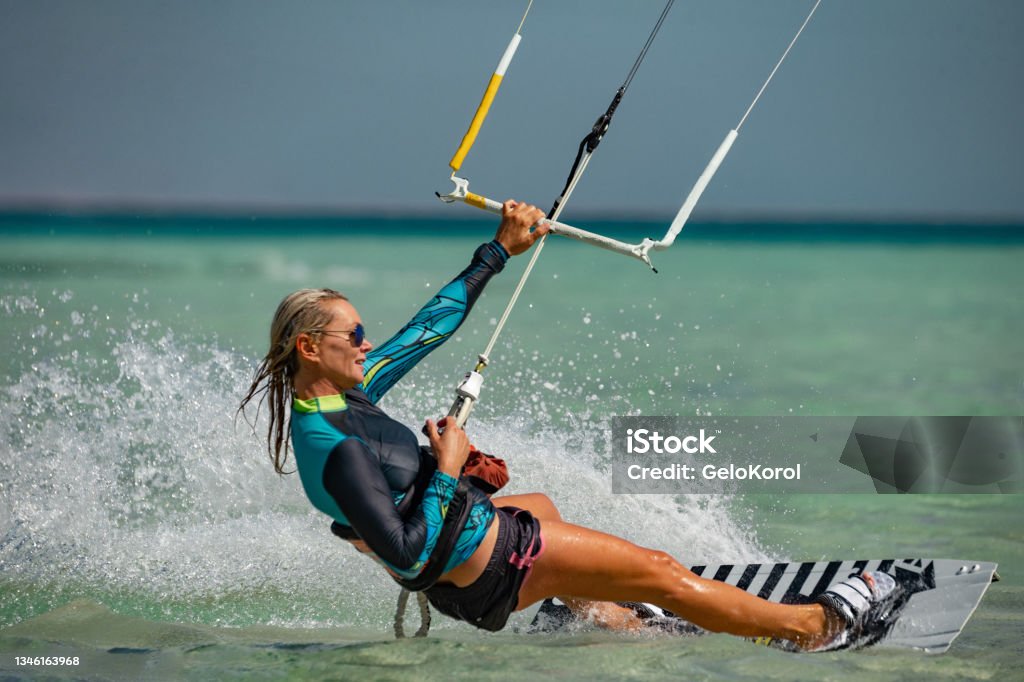Kite surfer woman rides with kiteboard  in transition Kiteboarding Stock Photo