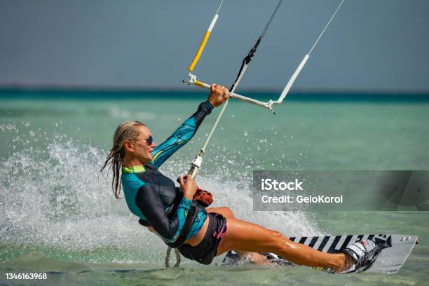Kite Surfer Woman Rides With Kiteboard In Transition Stock Photo - Download Image Now