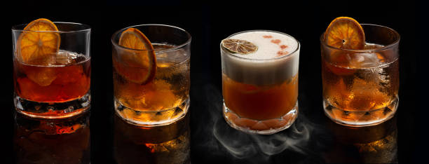 cocktails alcoolés: whisky stout sour, negroni fumé, cocktail à l’ancienne avec tranche d’orange sur fond noir - shot glass glass black empty photos et images de collection