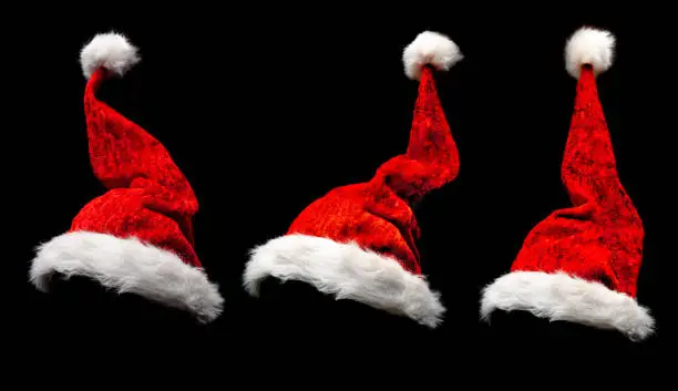 Red Christmas hats insulated against a black background