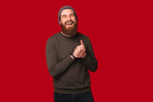 istock Laughing young bearded hipster man is holding hands together. 1346167943