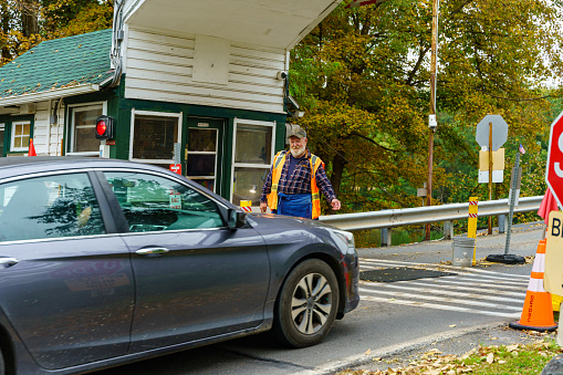 Dingmans Ferry, PA, USA - October 10, 2021: A toll collector is ready for payment tp use the Dingman Bridge, a privately owned toll bridge that crosses the Delaware River between NJ to PA.