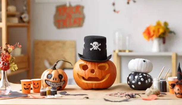 Photo of Classic carven spooky jack o lantern in pirate hat standing on wooden table