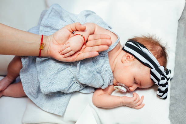 Mother's And Baby's Hand Newborn baby sleeping. Mother's and baby's hand. Safeness with mom. baby bracelet stock pictures, royalty-free photos & images