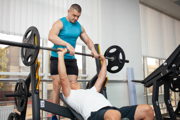 istock coach teaches man the correct technique of performing the exercise on the simulator in the gym. Weight loss, muscle building, healthy lifestyle, active, indoor. 1346170138