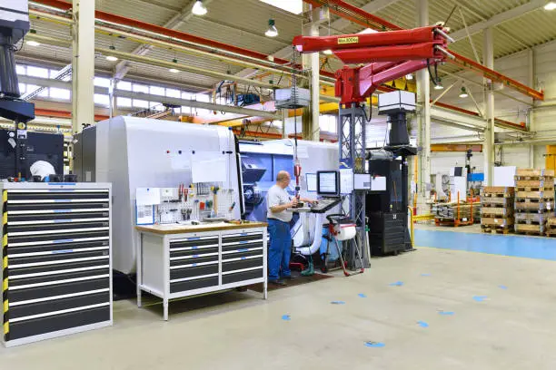 cnc machine in modern industrial mechanical engineering - workers at the workplace