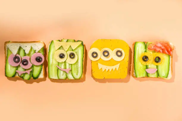 Various funny monster Halloween sandwiches. Set assortment creative breakfast snack toasts with cheese, Halloween kids party food, top view