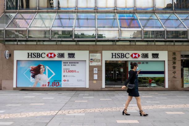 HSBC branch in Hong Kong Hong Kong - October 12, 2021 : A woman walks past the HSBC Hongkong and Shanghai Bank branch in Kowloon, Hong Kong. bank entrance stock pictures, royalty-free photos & images