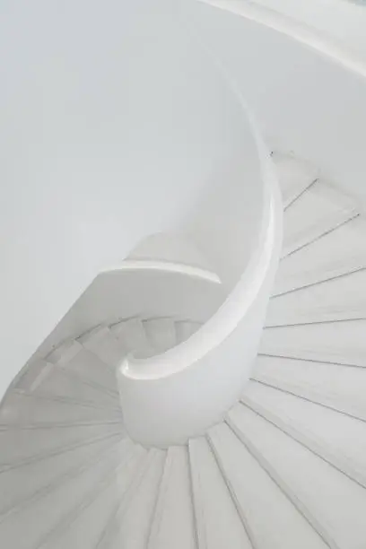 Photo of spiral grey white staircase with large copy space