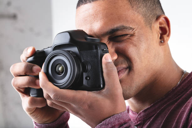 istock Young male photographer composing his image on camera 1346179561