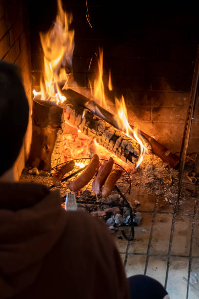 istock View over a human shoulder on pork saussages cooking over BBQ 1346180996
