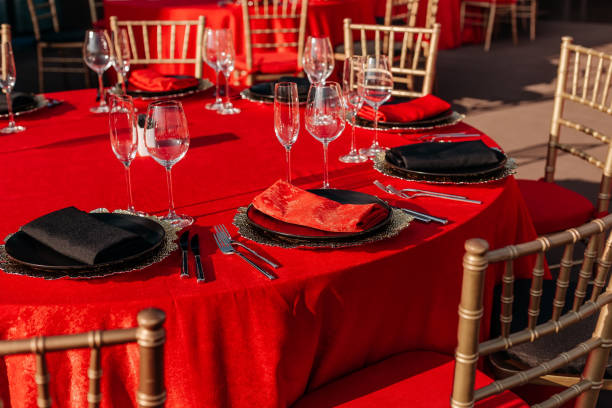 istock Guest table setting for banquet in black, red and gold style. Elegant and luxury dinner arrangement: decor, tablecloth, plates, glasses, napkins, cutlery. Themed birthday or wedding party celebration 1346181357