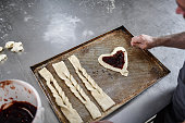 Baker Making Sesame Salt Sticks And Filling Heart Shaped Pastry With Jam