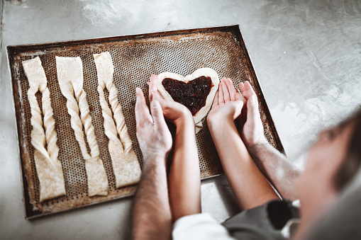 Couple Of Bakers Enjoying Love And Making Sweet Heart Shaped And Salty Pastries