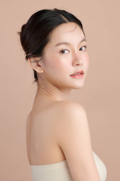 schöne junge asiatische frau mit sauberer frischer haut auf beige hintergrund, gesichtspflege, gesichtsbehandlung, kosmetologie, schönheit und spa, asiatische frauen porträt. - beautiful image head and shoulders vertical stock-fotos und bilder