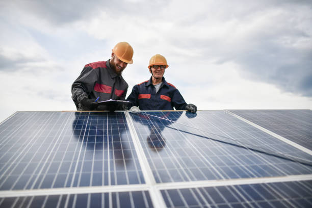 istock Senior Worker And Younger Colleague Measuring Solar Panel Diagonally And Documenting It 1346185745
