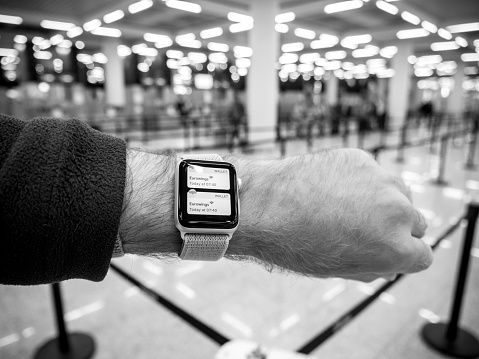 Barcelona, Spain May 11, 2018: Crop male hand with smartwatch using Apple Watch Series 3 device while standing in light modern airport