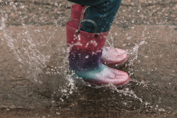 istock Splashing in a buddle in rainbow rainboots 1346189948