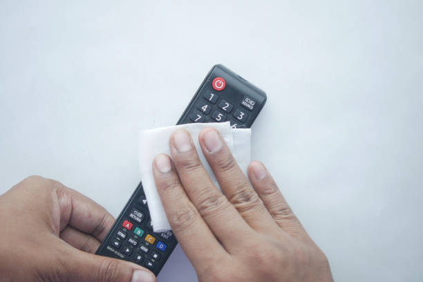 istock Cleaning Tv remote control with an antibacterial fabric tissue.. 1346190324