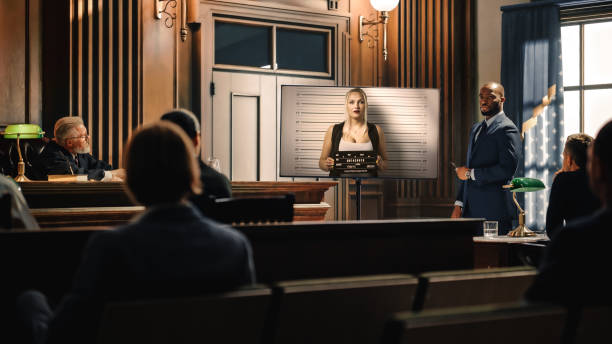 Court of Law Trial in Session: Portrait of Charismatic Male Public Defender Showing Guity Arrested Girl on TV Display to Judge and Jury. Attorney Lawyer Protecting Client, Presenting Case. juicio en sesión en el tribunal de justicia: retrato del carismático defensor público masculino que muestra a la niña arrestada de guity en la exhibición de televisión al juez y al jurado. abogado abogado protegiendo al cliente, presentando caso.