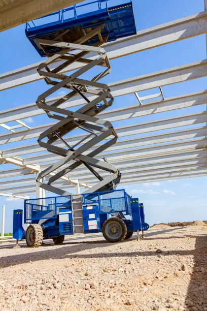 Photo of Mobile scaffold, stretched scissor lift platform at construction site