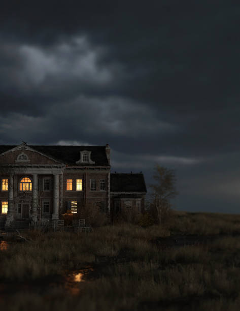 istock Ominous dilapidated and abandoned mansion on the prairie with illuminated interior lighting under a dark cloudy sky. 3D rendering. 1346190687