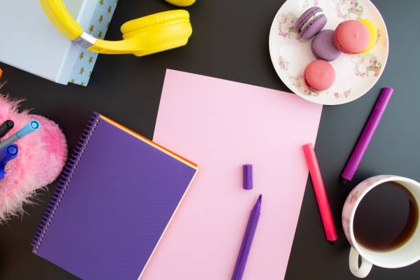 istock paper, notebook, colored pencils, macarons on a black background 1346194908