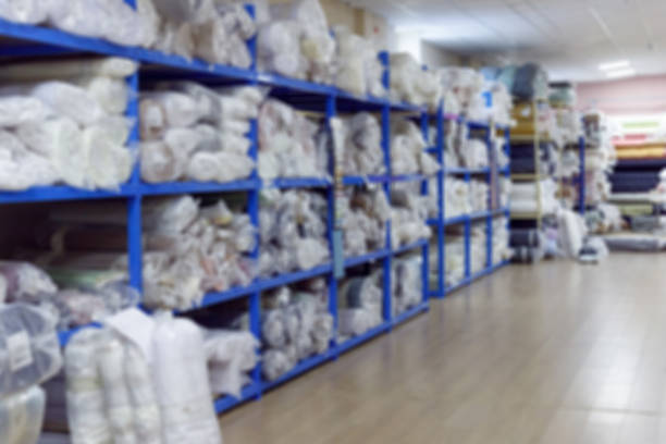 Blurred interior of industrial warehouse with fabric rolls.